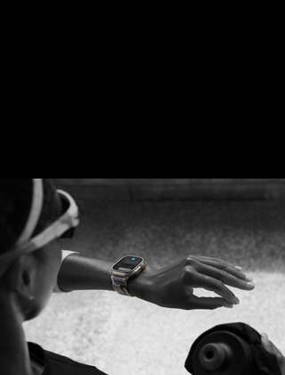 En løber kigger på Apple Watch Ultra 2 på sit venstre håndled og laver håndbevægelsen dobbelttryk med sin pege- og tommelfinger på venstre hånd
