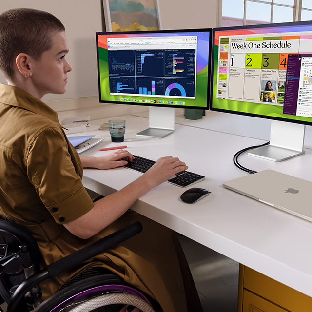 En person arbejder ved to eksterne skærme, der er tilsluttet en sammenklappet 15" MacBook Air i farven stjerneskær