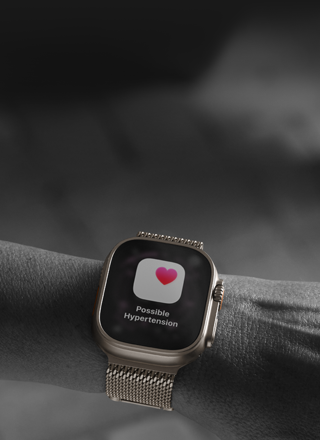 Person med Apple Watch Ultra 3 på håndleddet, der viser en sundhedsmeddelelse om muligt forhøjet blodtryk på skærmen