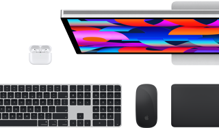En samling af tilbehør og enheder, der blandt andet omfatter AirPods, Magic Keyboard med Touch ID, Magic Mouse, Magic Trackpad og Studio Display