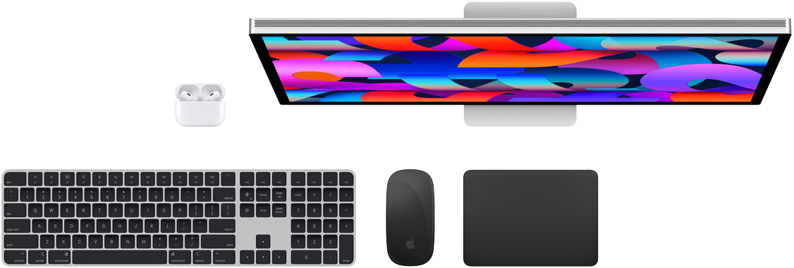 Mac-tilbehør set oppefra: Studio Display, AirPods, Magic Keyboard, Magic Mouse og Magic Trackpad